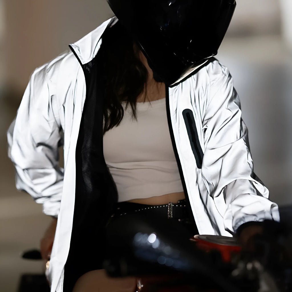 Silver coloured waterproof polyester long sleeved coat with hood on a hanger.
