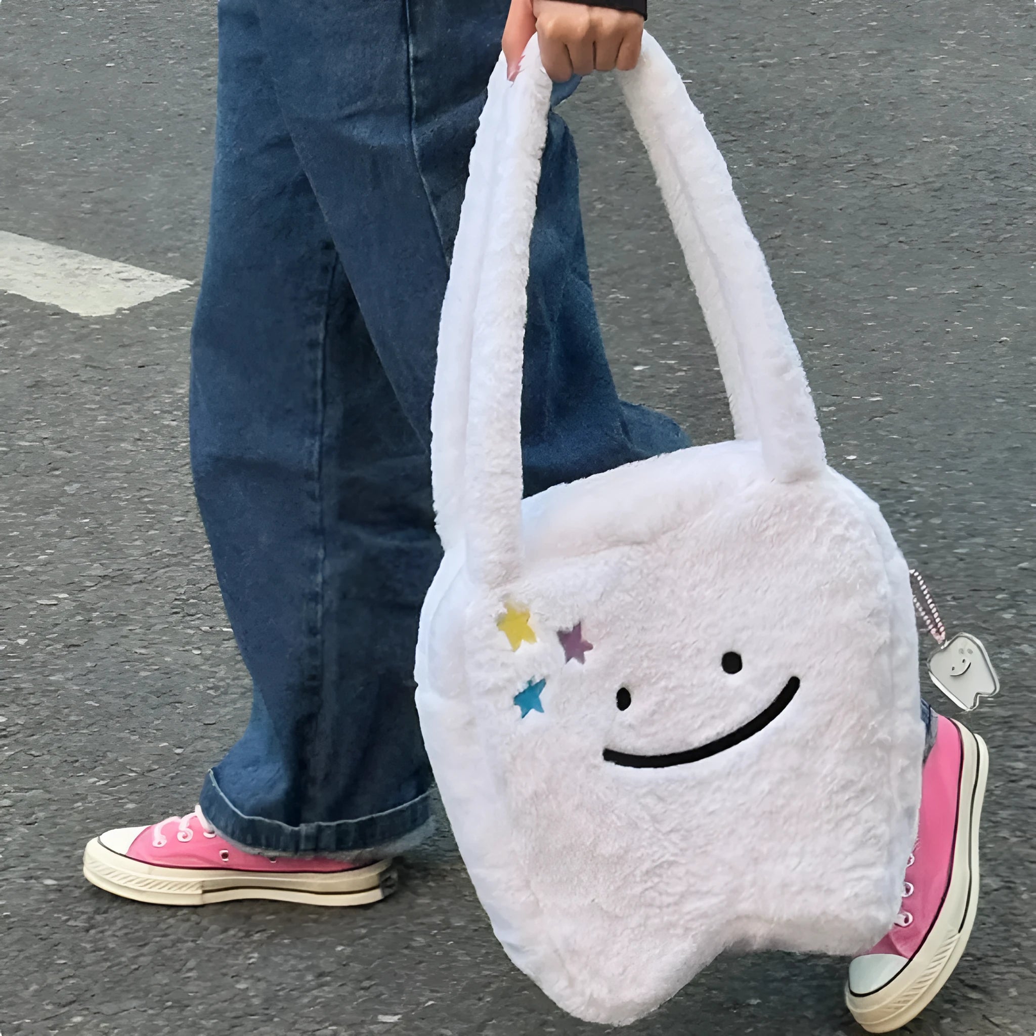 White plush tote bag with large cute teeth graphic, showing crossbody strap and zip opening.