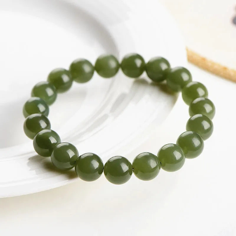 Polished Hetian Jade ball bracelet in clear water colour on a wrist, showing multiple bead sizes.