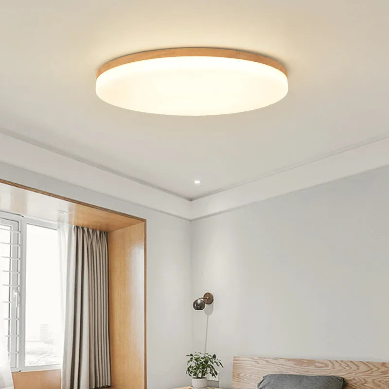 Japanese minimalist wood and acrylic LED ceiling lamp with a round acrylic shade on a wood body.