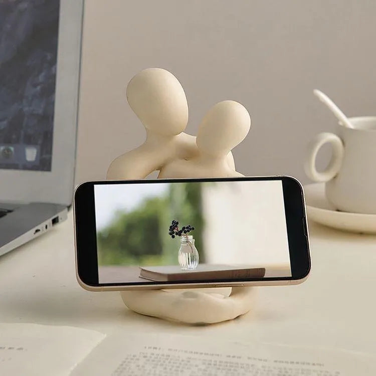 Modern milky white resin statue of a loving couple on a wooden desk.