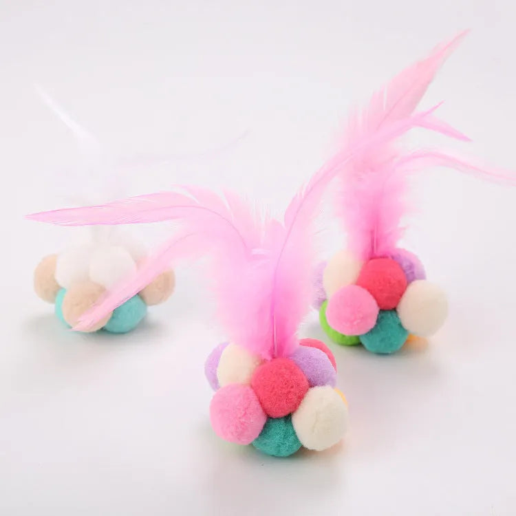 Colourful cat toy feather bouncy ball with pink feathers on a white background