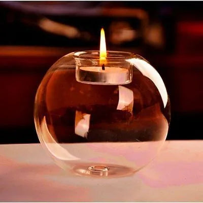 Handmade clear hollow glass spherical candle holder in European style on a table.