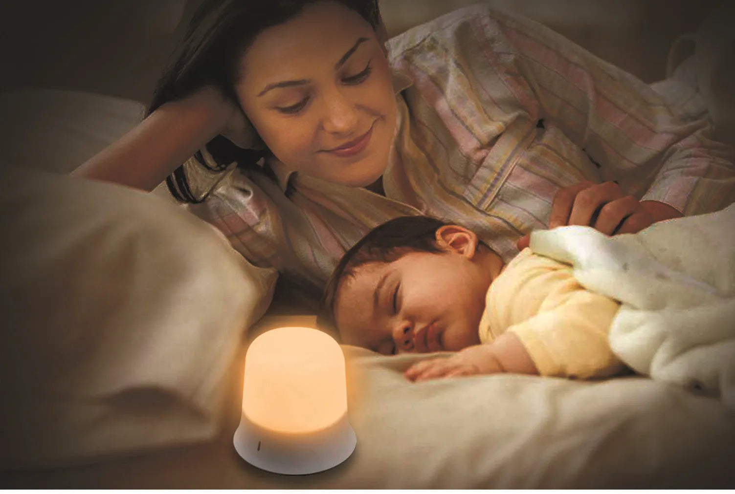 White cylindrical touch-control bedside night light with rechargeable battery on a table.