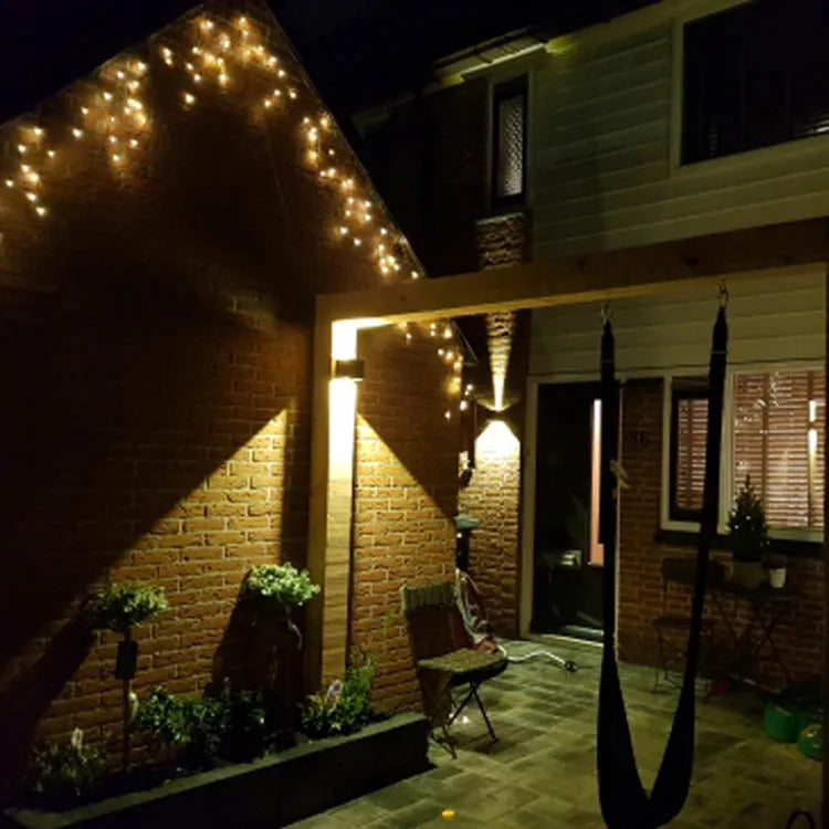 Square black aluminium alloy LED wall lamp mounted on a brick wall, showing 360-degree light emission.