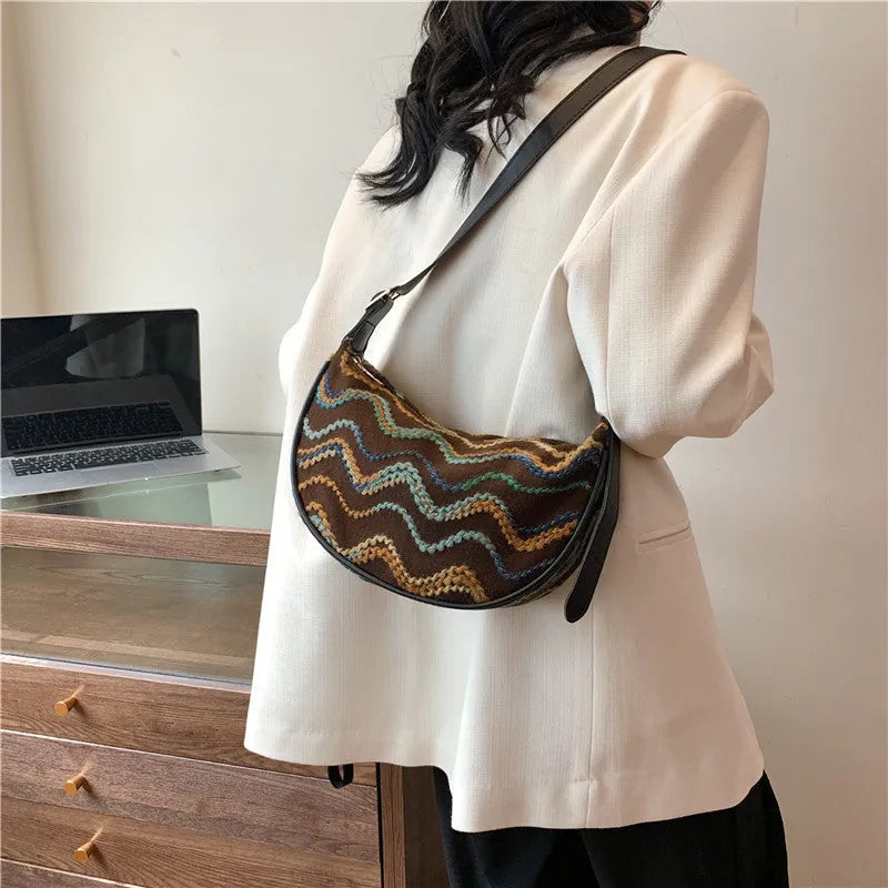 Women's knitted straw woven crossbody bag in corrugated black carrying phone and files