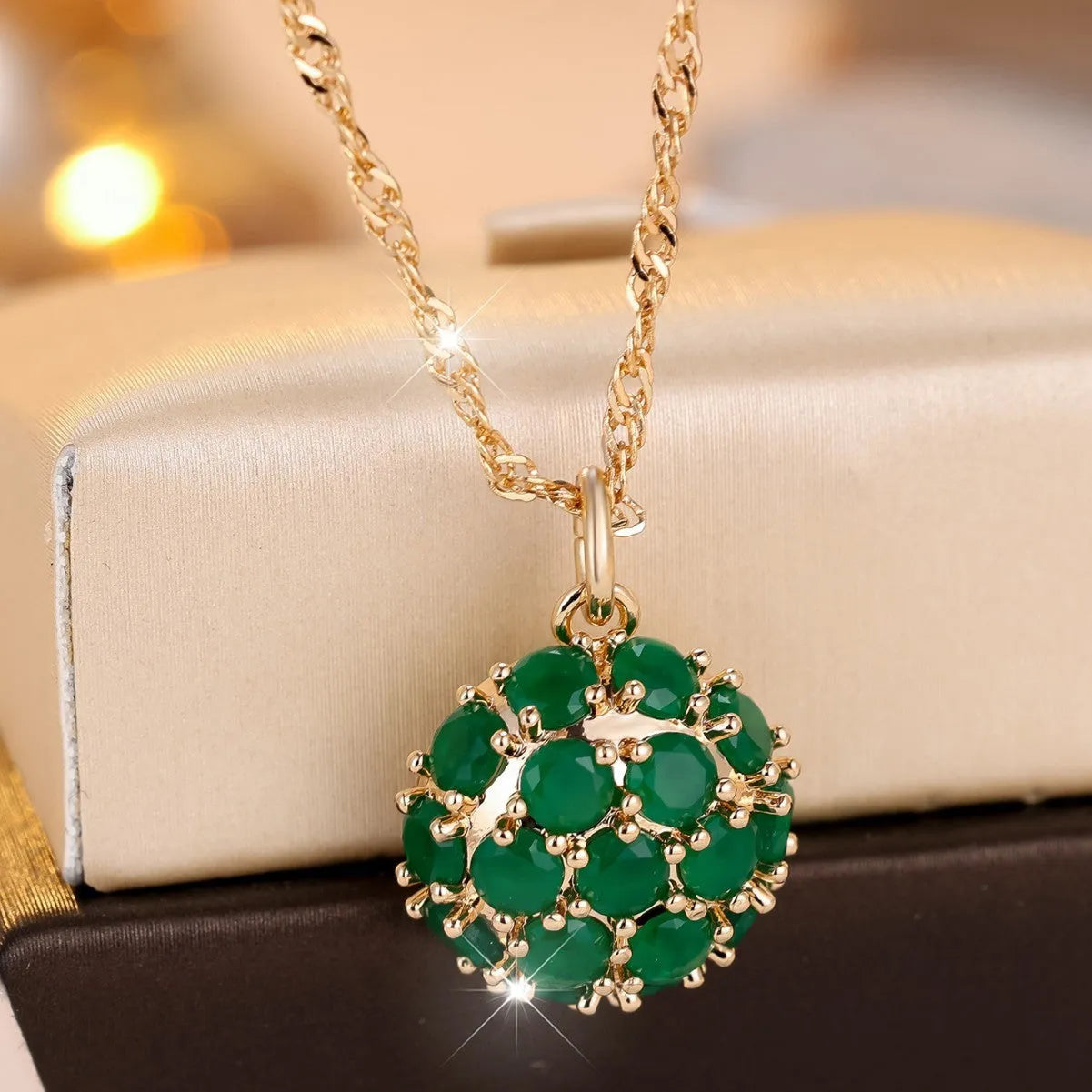 Geometric pendant necklace with emerald and diamond detailing on adjustable champagne gold chain