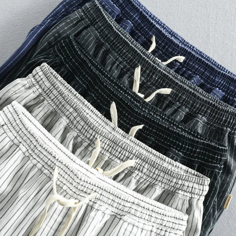 Man wearing black and white striped casual cotton shorts with a loose straight fit.