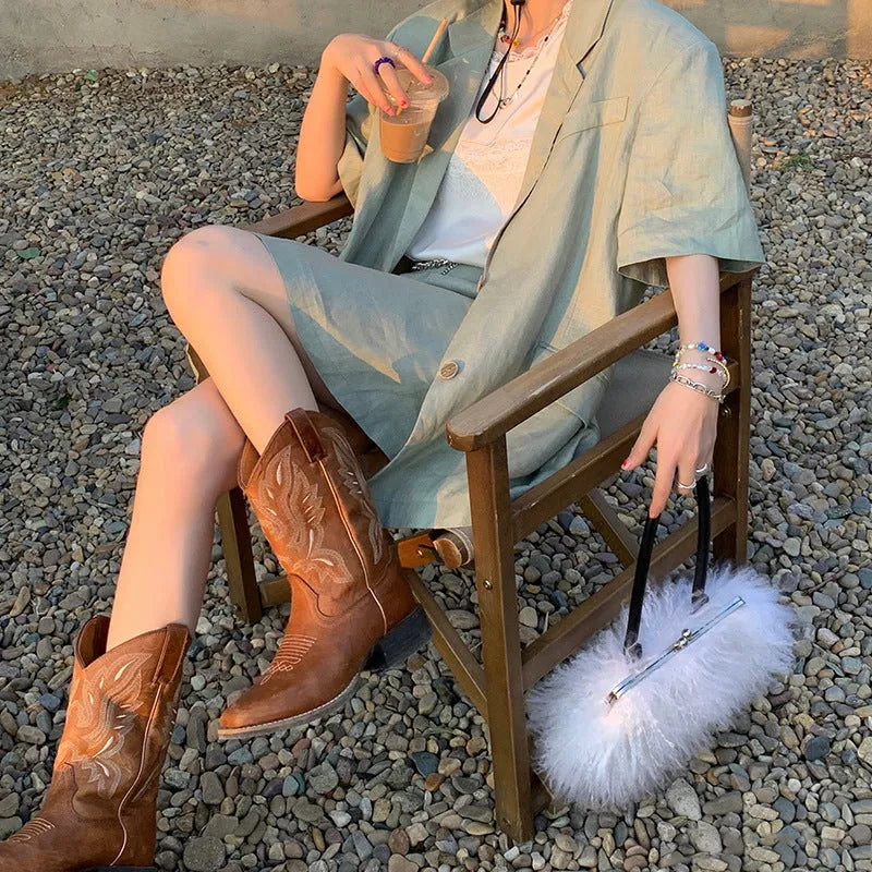 Brown women's embroidered mid-calf Martin boots with leather lining and a square heel.