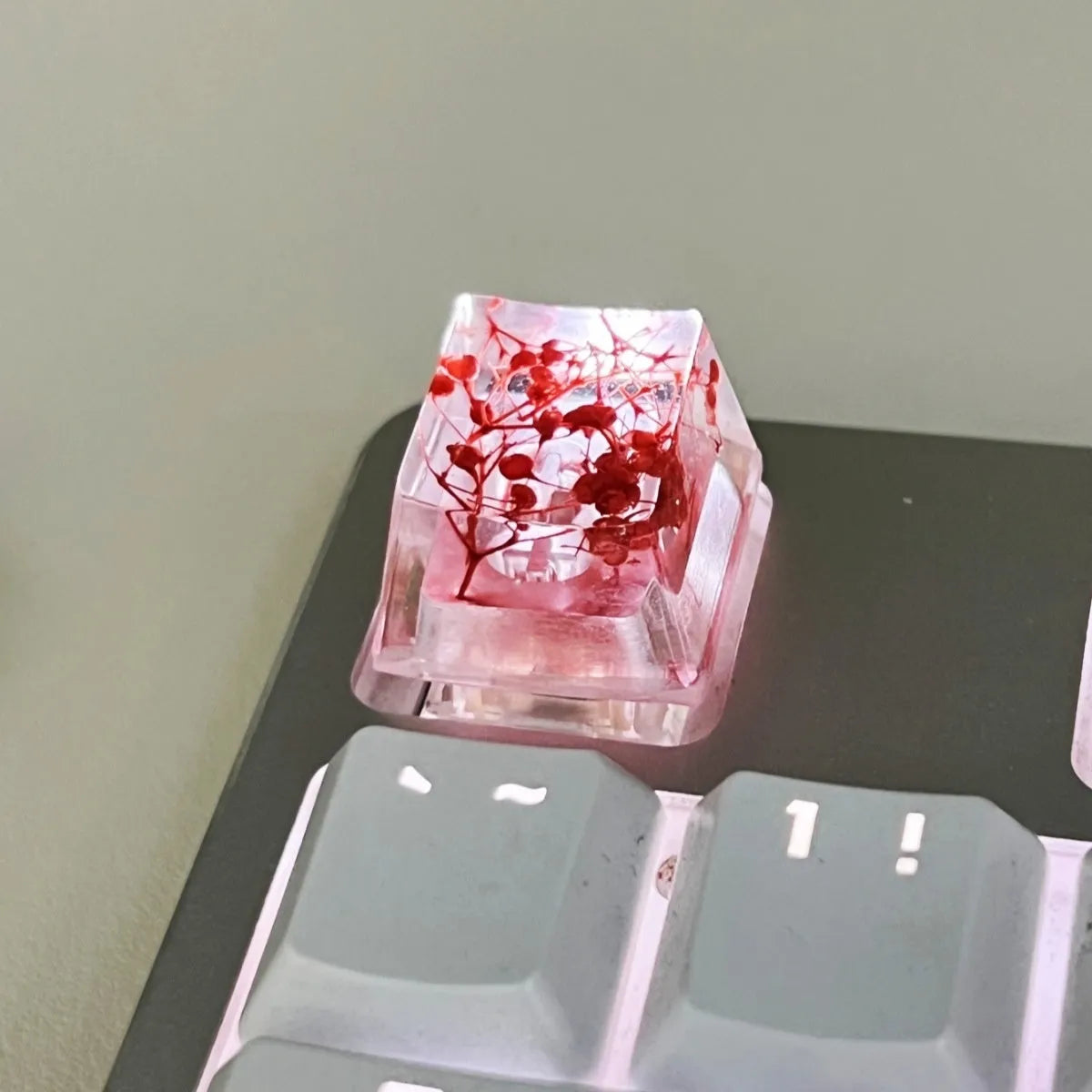 Transparent resin mechanical keyboard keycap with starry sky design in green, pink, red, violet colours.