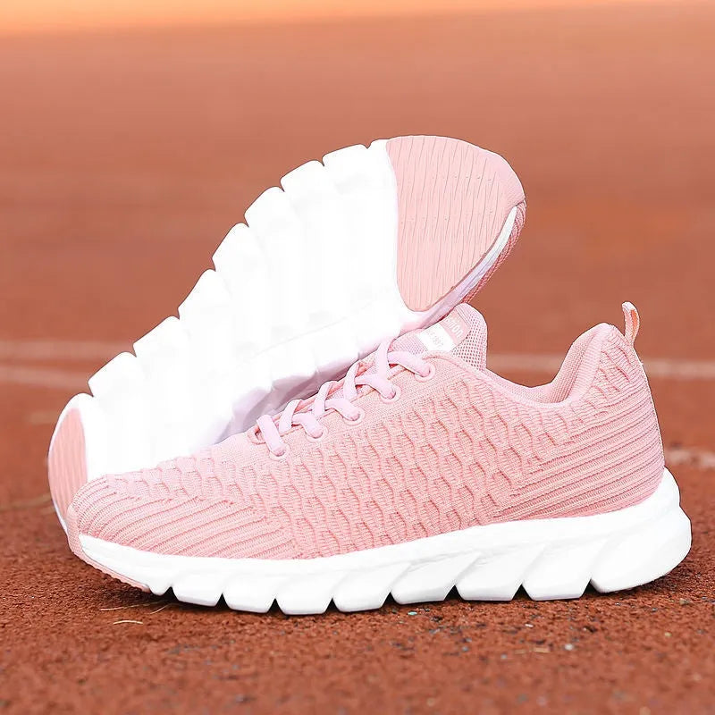 Women's black running shoes with a fly weave upper and a durable outsole on a track.