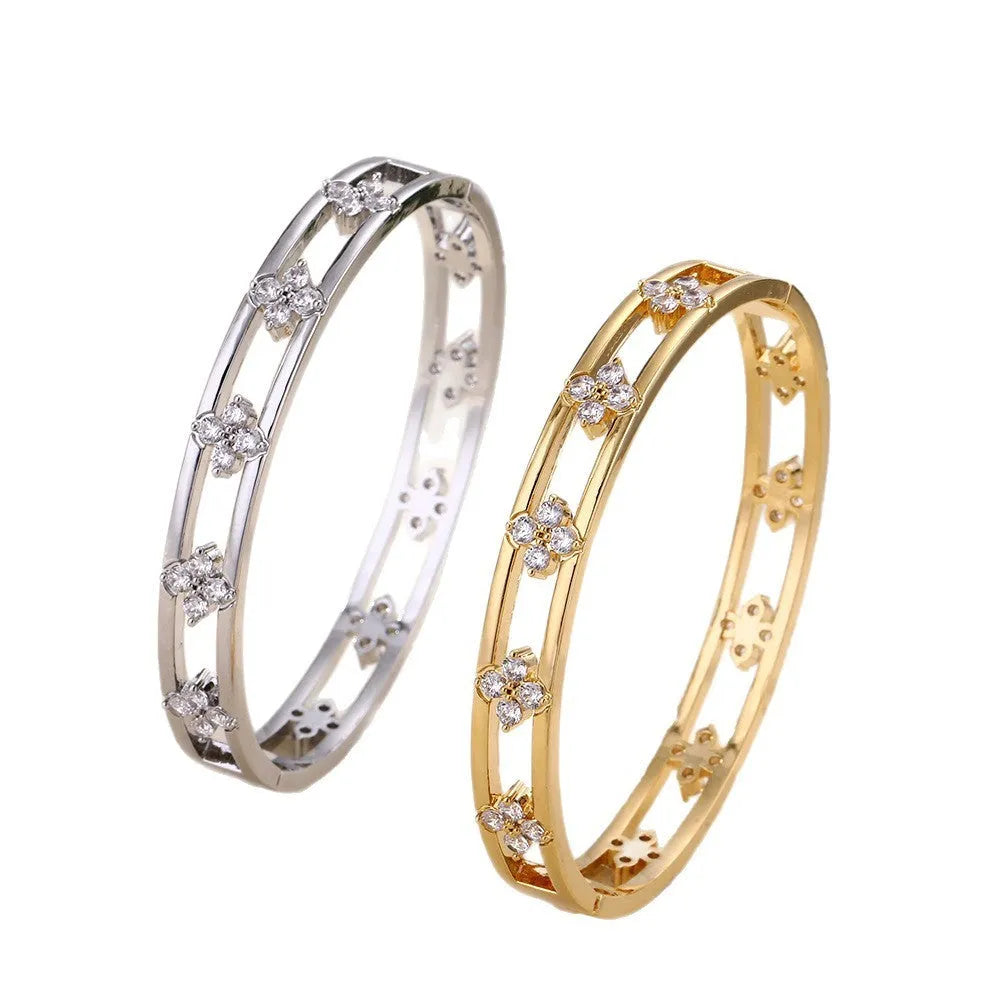 Gold or silver plated women's hollow bracelet with a four-leaf clover charm and zircon stones.