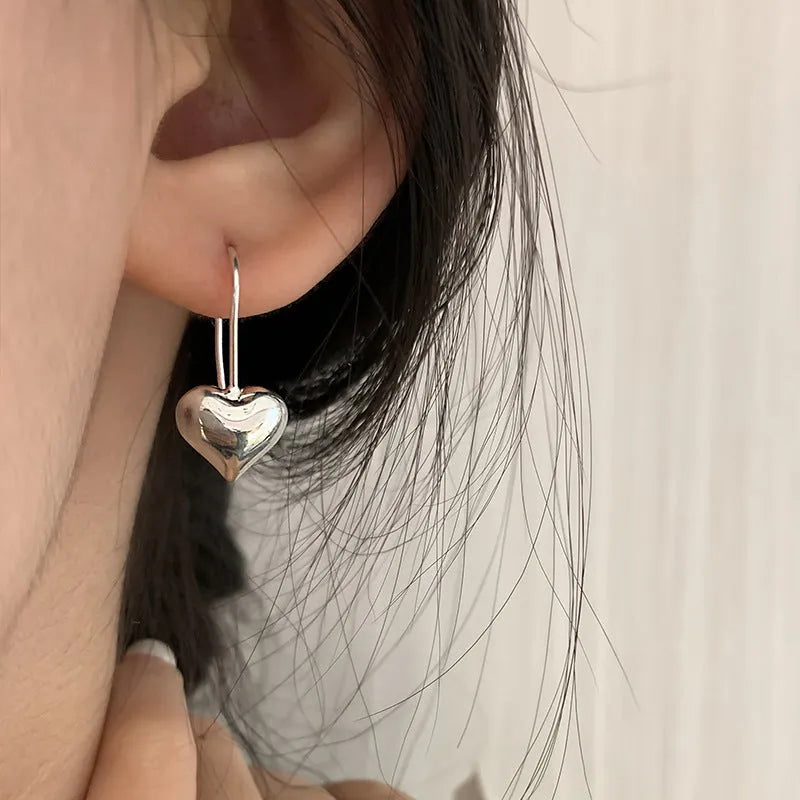 Silver heart shaped earrings with glossy three-dimensional Korean style design