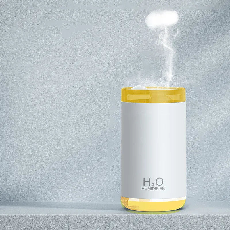 White jellyfish USB humidifier with night light on wooden surface showing mist output