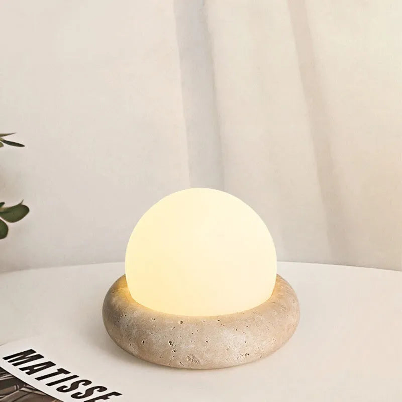 Cream coloured remote control bedside night lamp with yellow cave stone light on wooden table