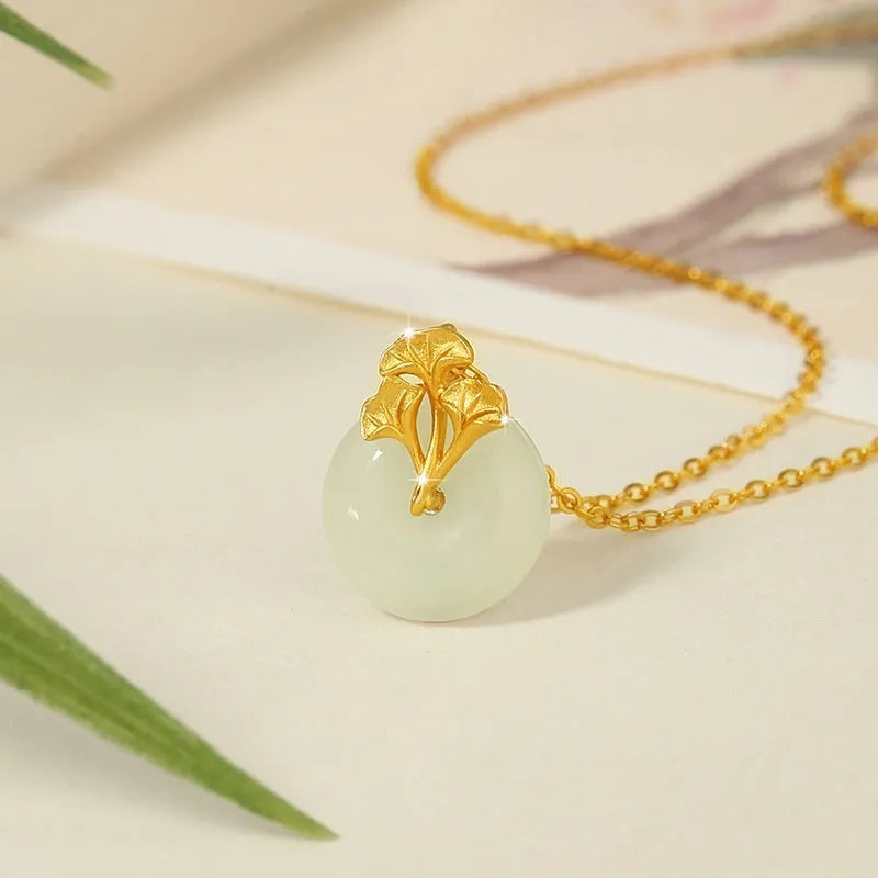 925 sterling silver ginkgo leaf pendant necklace, gold finish, with peace buckle and adjustable 41-50 cm chain on model clavicle
