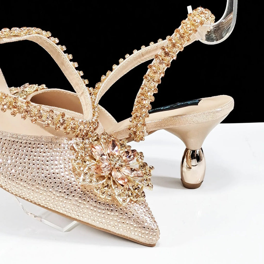 Women's black high heel and matching clutch bag set with rhinestone floral decoration and pointed toe.