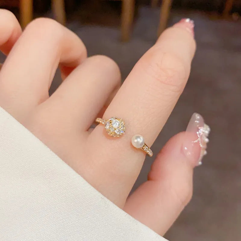 Open-end women's ring with round zircon stone on geometric band in gold or silver finish.