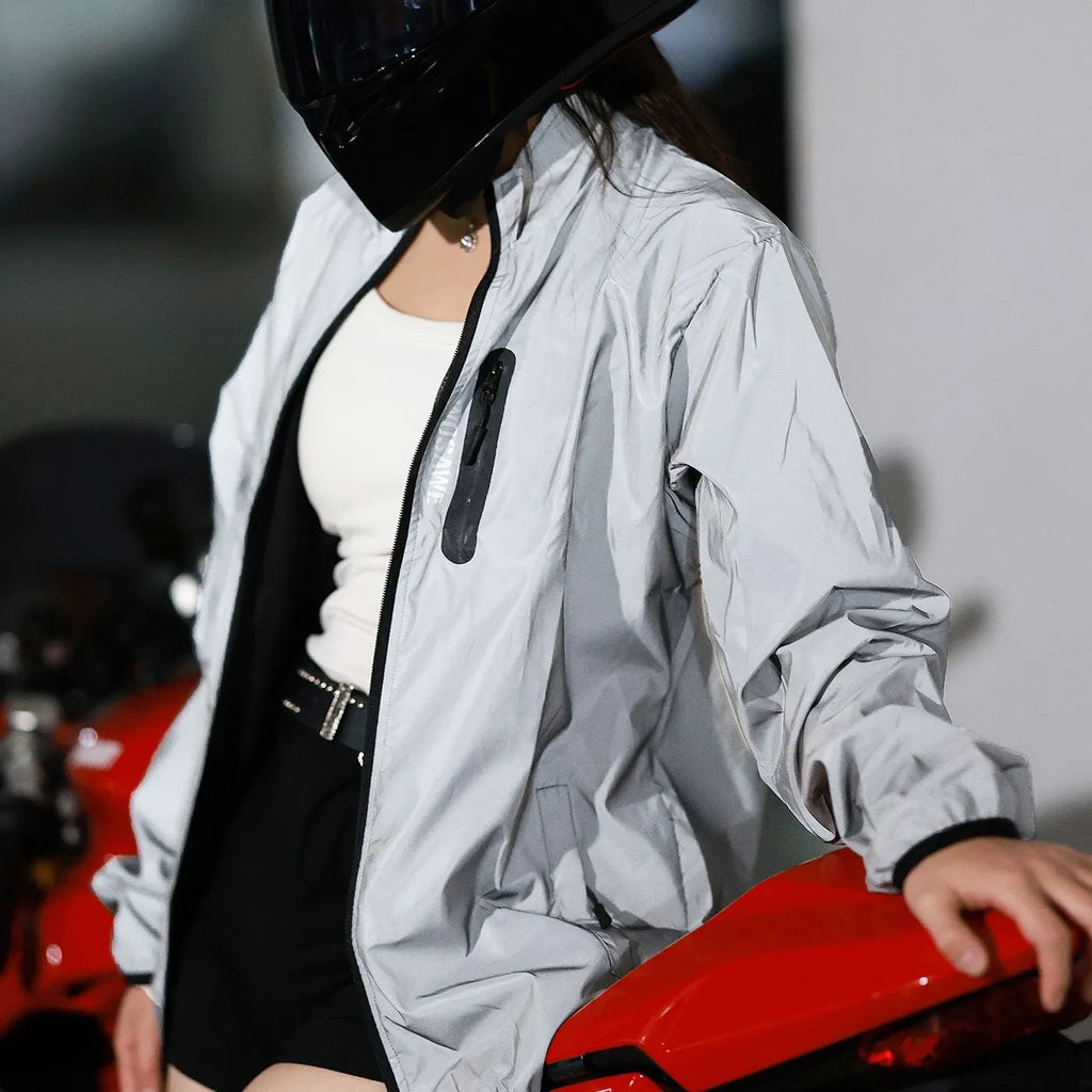 Silver coloured waterproof polyester long sleeved coat with hood on a hanger.