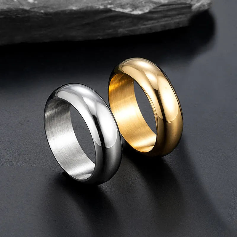 Glossy electroplated titanium steel ring in gold colour on a plain background.