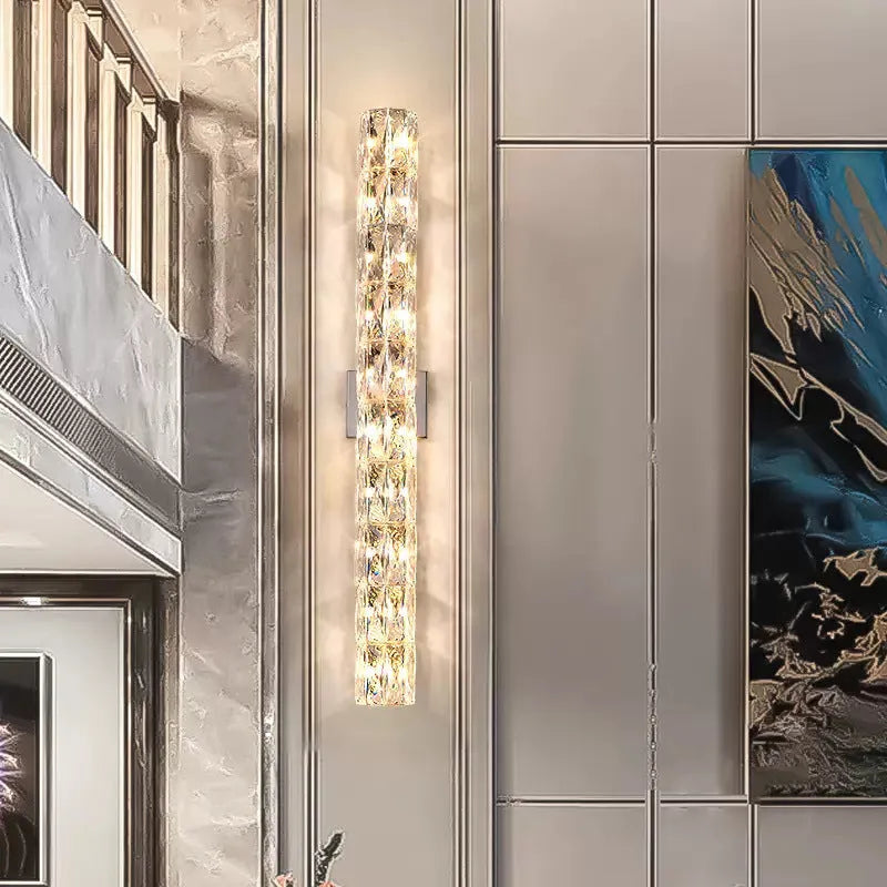 Modern crystal shade wall lamp in gold or chrome stainless steel, mounted on a wall.