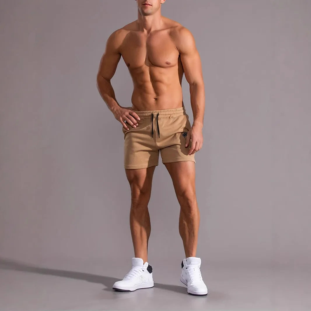 Men's khaki sports shorts with a coconut leaf pattern, showing a straight-leg fit and elasticated waistband.