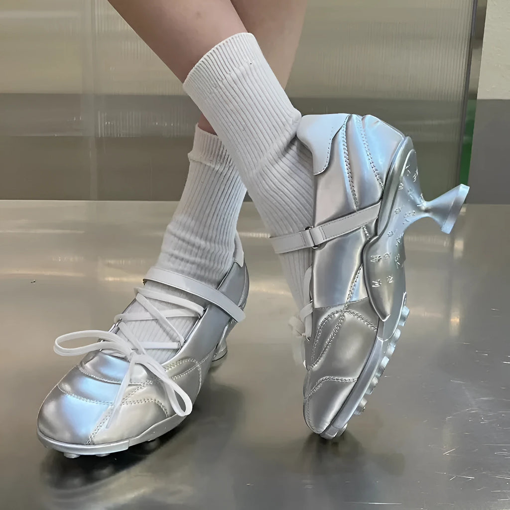 Women's silver sports shoes with a front lace-up bow and a mid heel on a white background.
