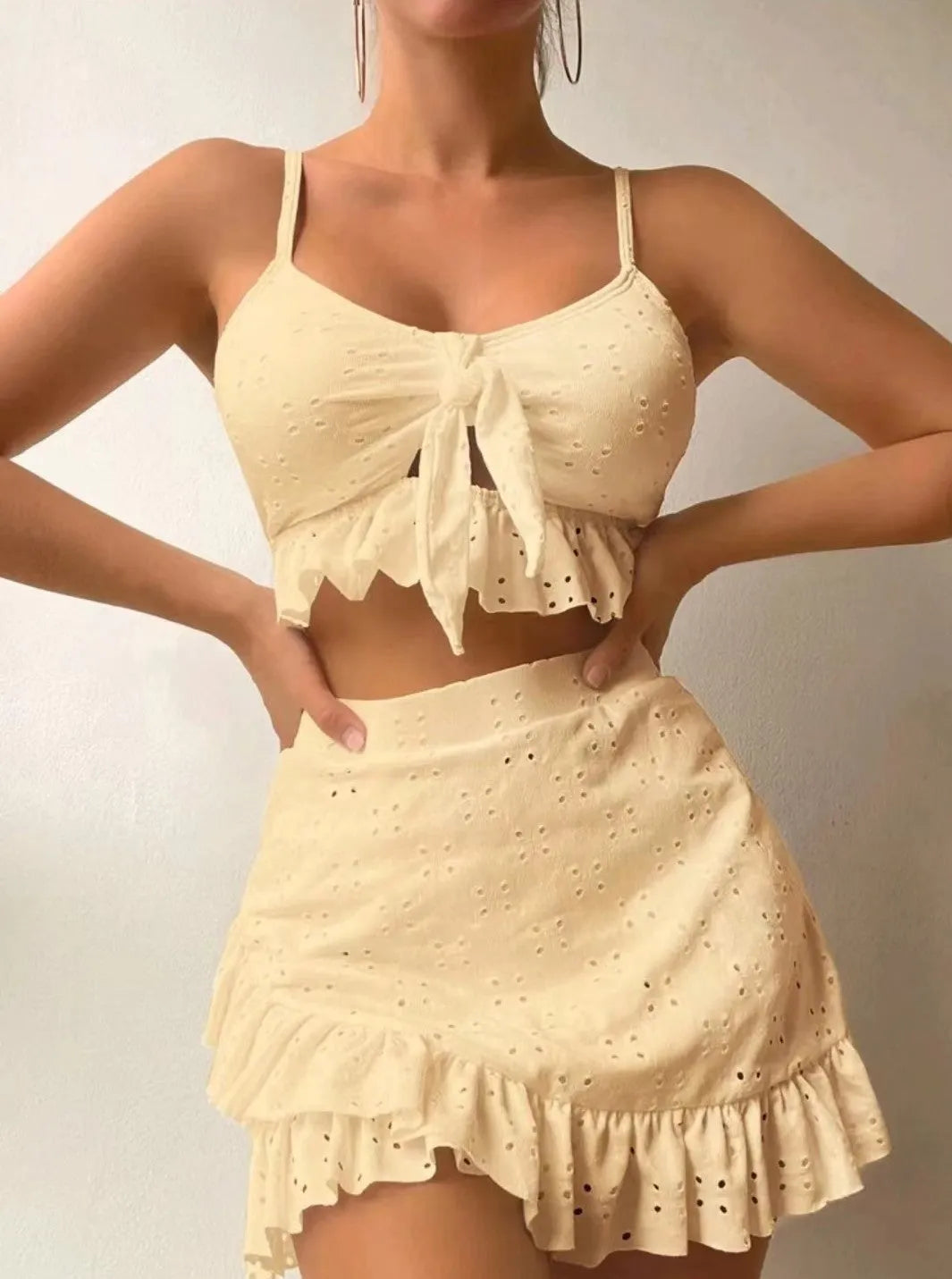 Women's solid colour three-piece bikini swimsuit with a split hip skirt.