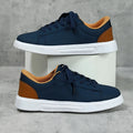 Beige brown casual platform sneakers with a cross strap and round toe on a rubber sole.
