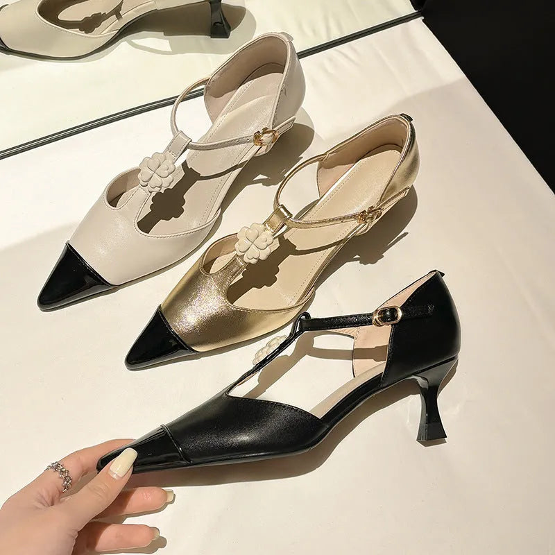 Women's black sheepskin stiletto heel shoe with flower buckle detail on a pointed toe.