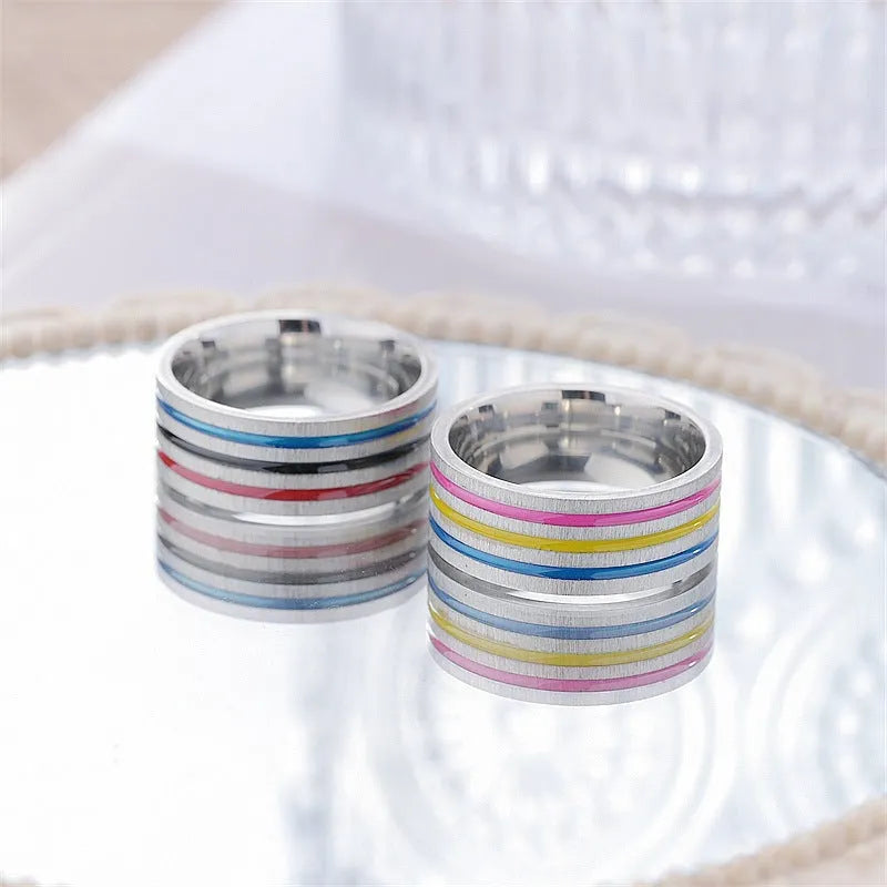 Silver titanium steel ring with rainbow drops of oil pattern and flower shape on white background