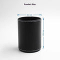 Round black leather pen holder container on desk with pens inside