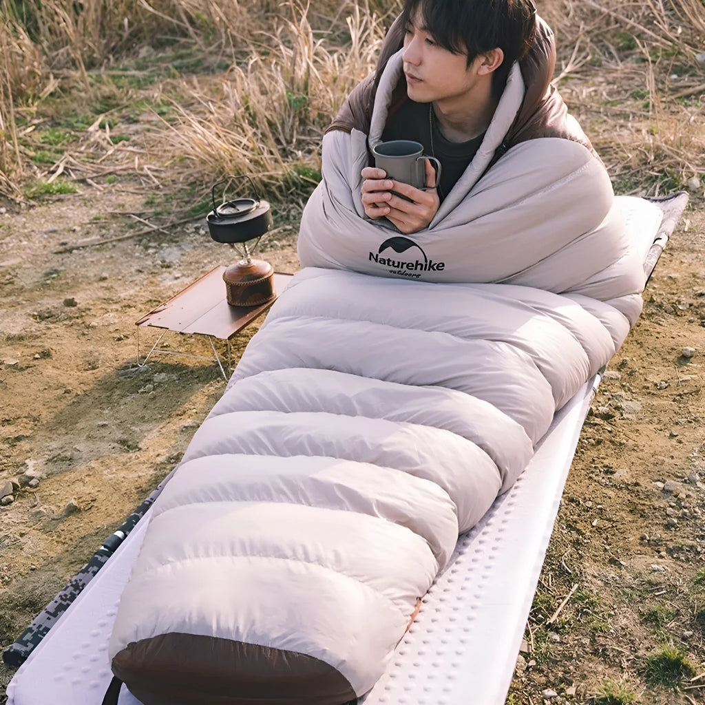 Mummy-style goose down sleeping bag for adults in a storage bag, showing size label options.