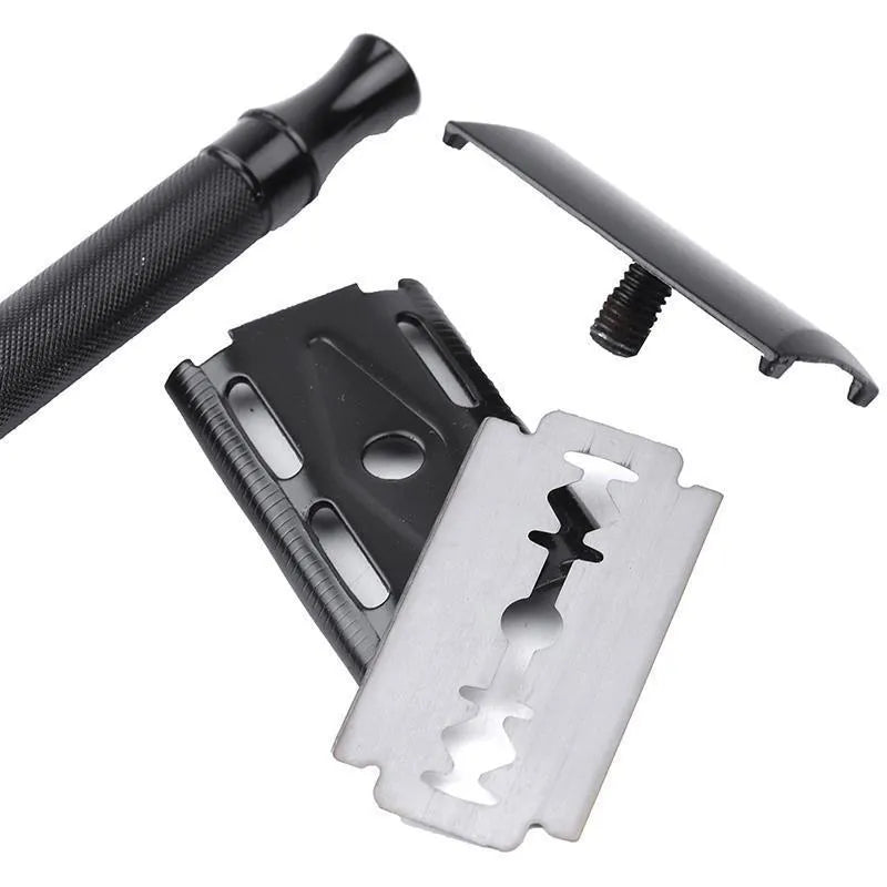 Traditional manual shaving razor and brush set in silver and black finish on a wooden surface.