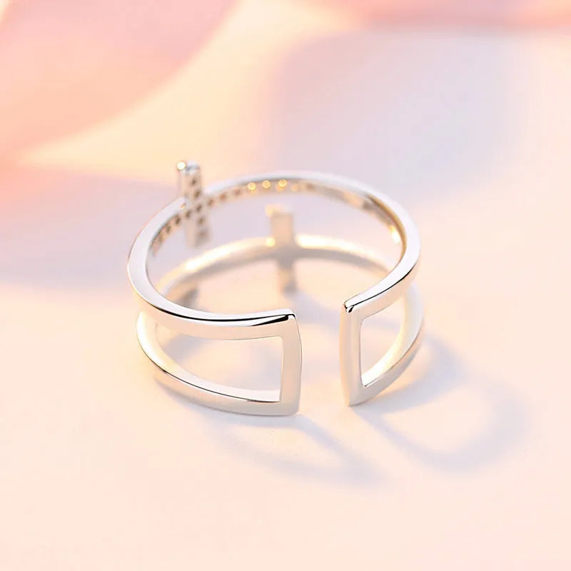 Adjustable double cross geometric ring in white gold colour with sterling silver and zircon gem inlay.