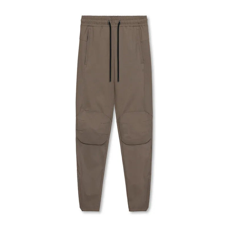 Men's ankle-tied loose fit running pants in a quick-dry fabric, shown in olive green colour.