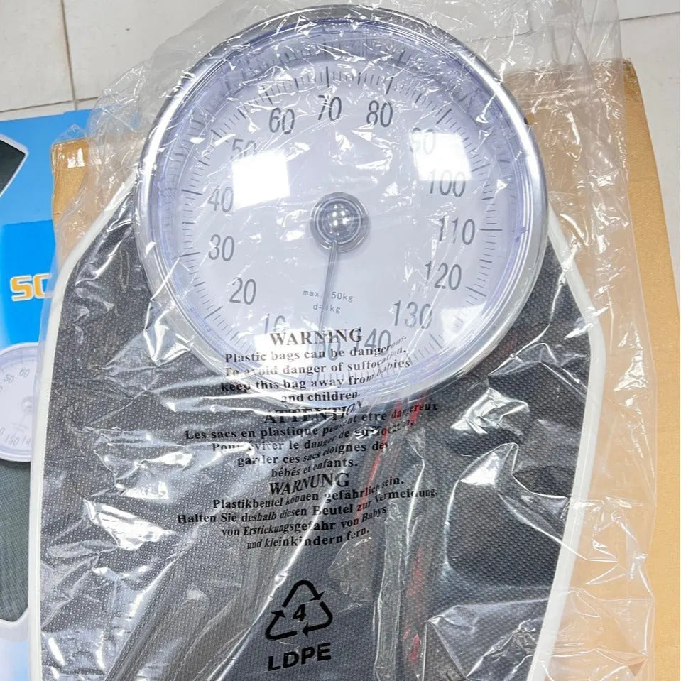 Black mechanical bathroom scale with large analogue dial showing weight measurement