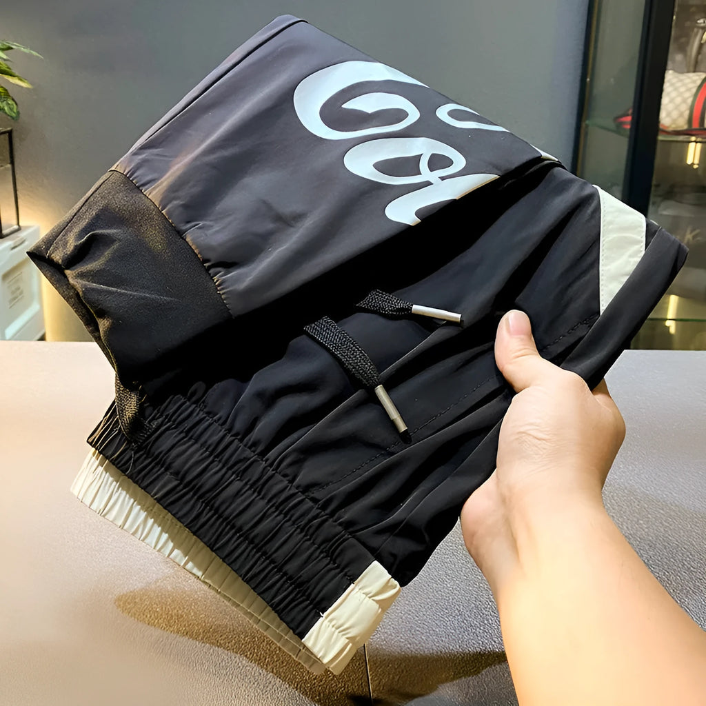 Men's black cropped ankle band trousers in ultra-thin ice silk cotton material showing casual styling