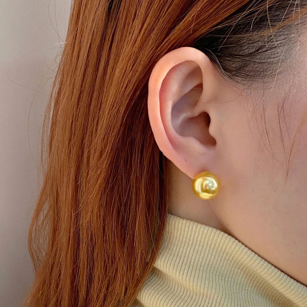 Large pearl stud earrings in geometric shape with eight awn star detail and pearl accents on silver background