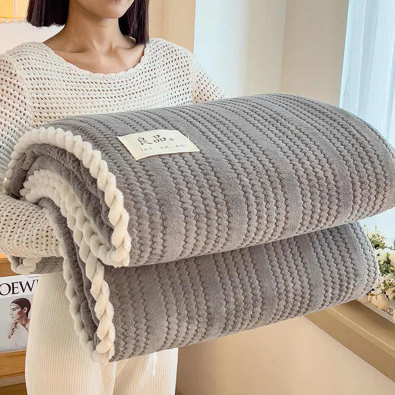 Solid colour jacquard milk velvet blanket in cream white on a bed with Nordic-style decor