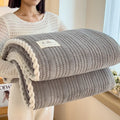 Solid colour jacquard milk velvet blanket in cream white on a bed with Nordic-style decor