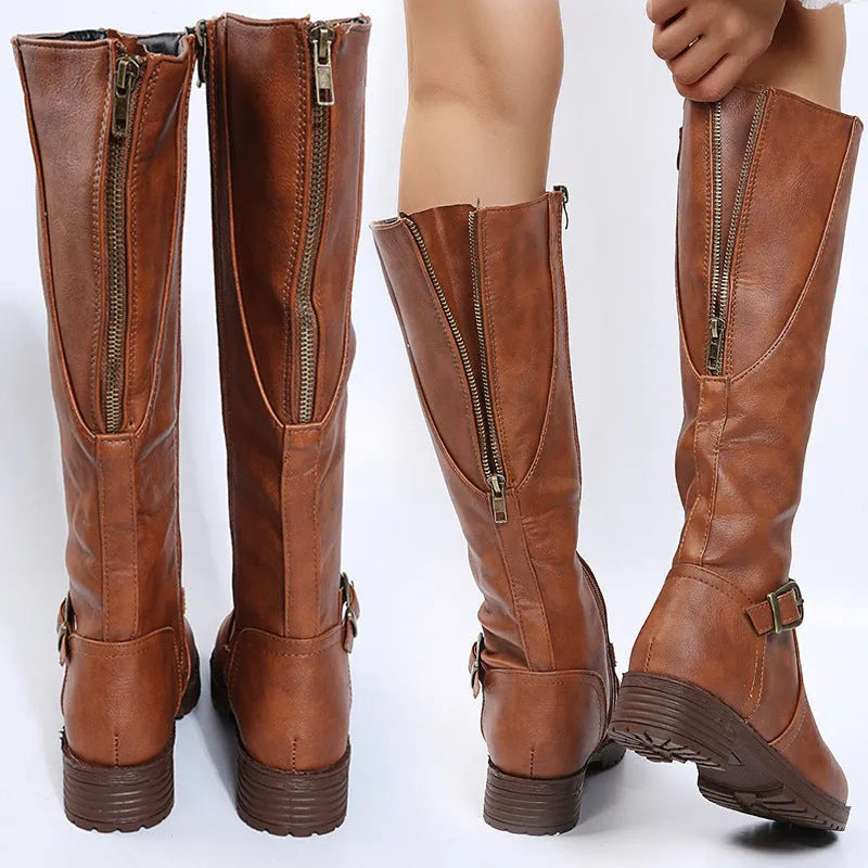 Women's black knight boots with belt buckle details and square heel on model