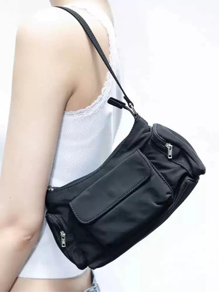 Black nylon lightweight shoulder bag with double pockets and side line detailing.