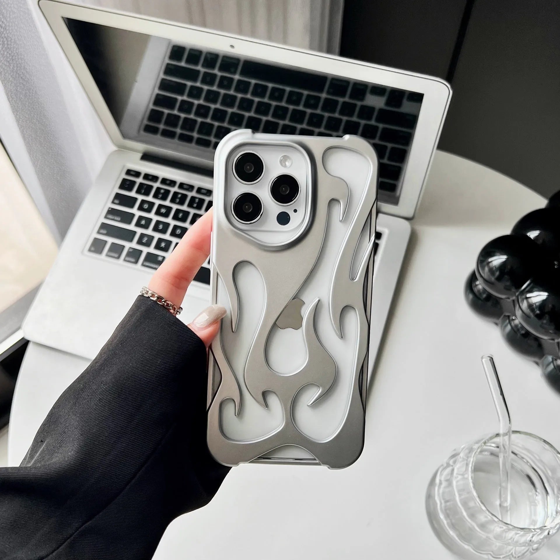 Electroplated hollow flame pattern design on a soft TPU iPhone case, shown in a silver finish.