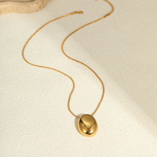 Gold geometric pendant necklace on adjustable chain against white background