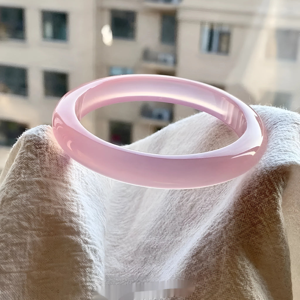 Natural agate wide tyre bracelet in pink stone showing band design and size options.