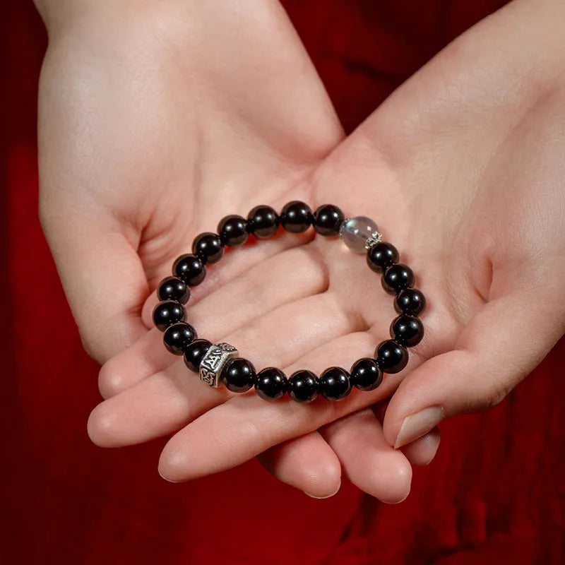 Obsidian bracelet with 8mm beads carved with zodiac animals and bodhisattva figures.