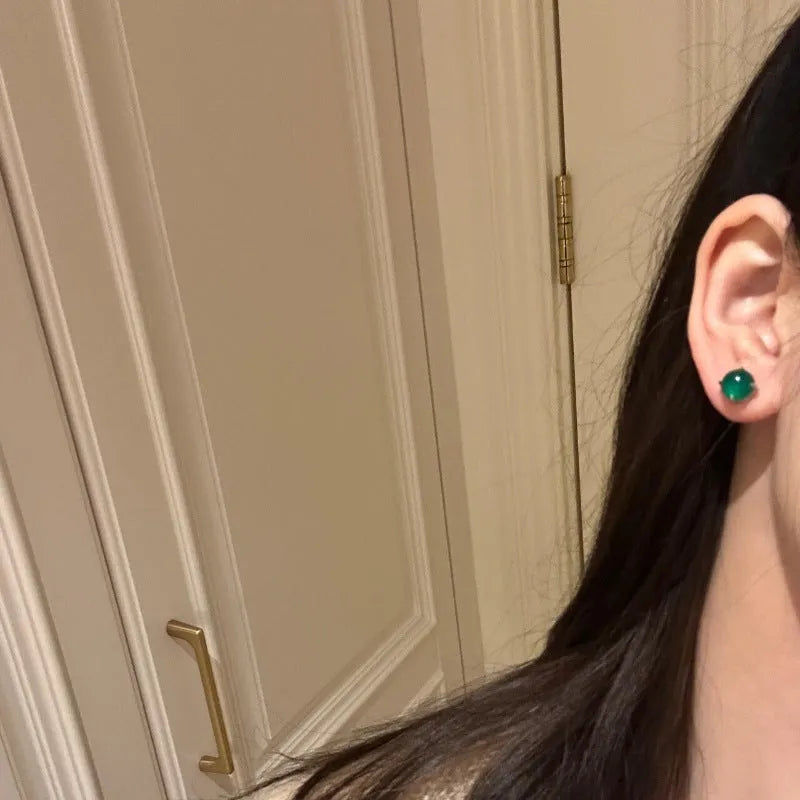 Round egg surface chalcedony stud earrings with four-claw copper settings in green, white, or pink.