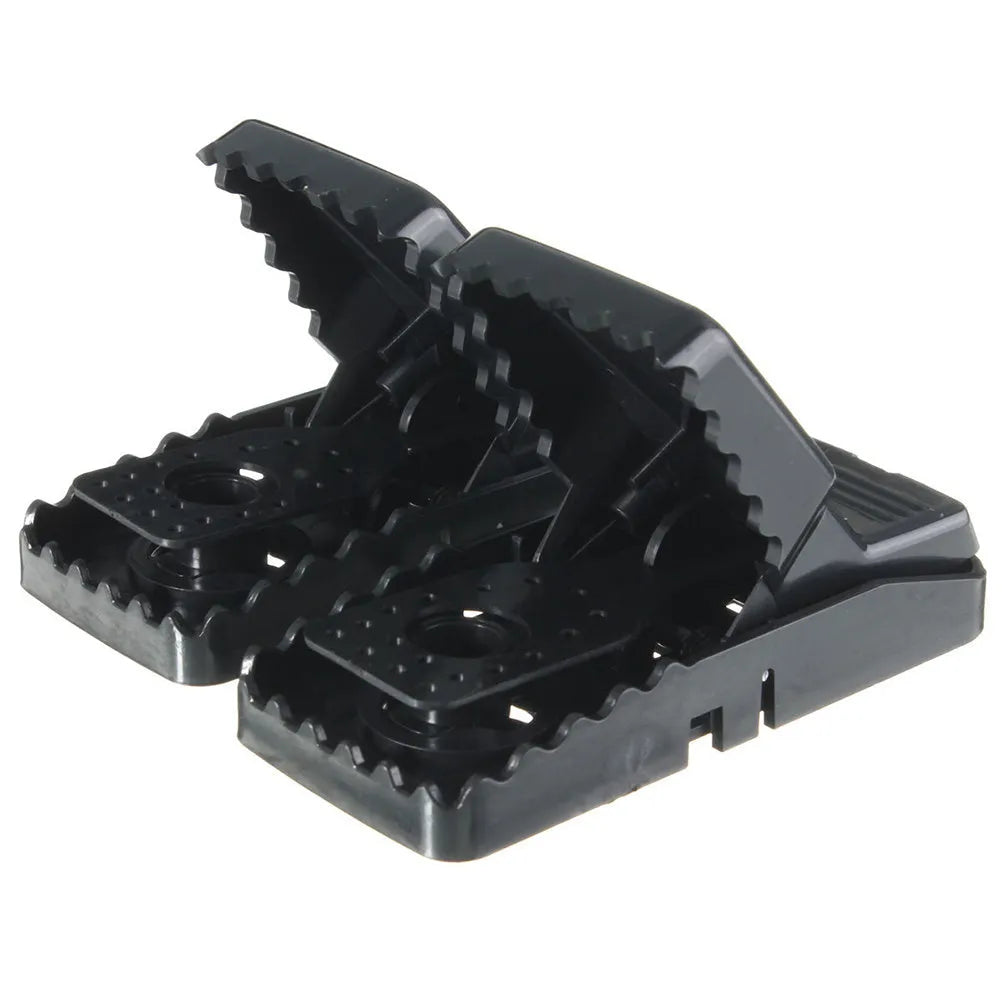 Set of six black plastic snapping mousetraps with smooth surfaces, shown next to a ruler for scale.