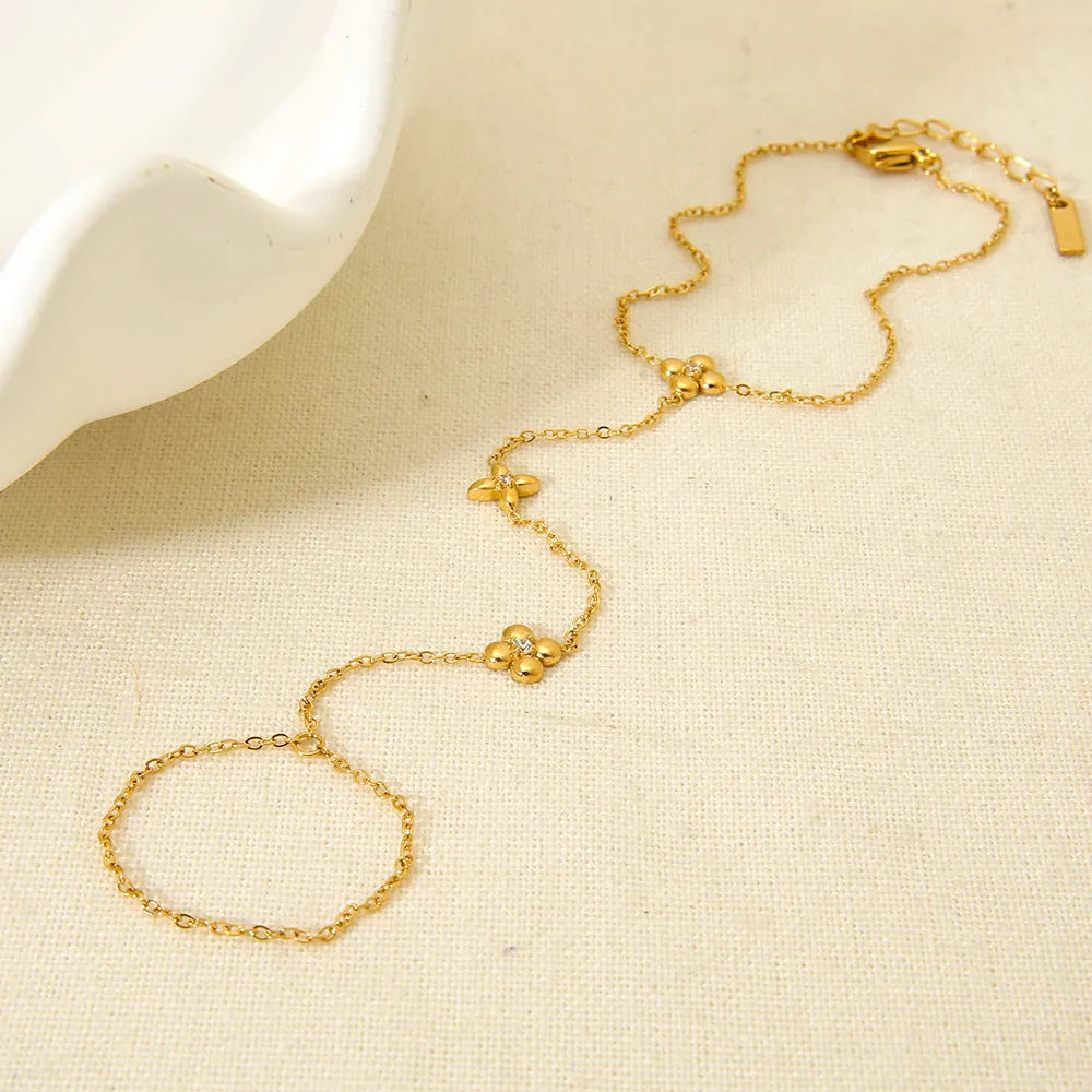 Gold-coloured stainless steel women's bracelet with eight-pointed star and floral charm design